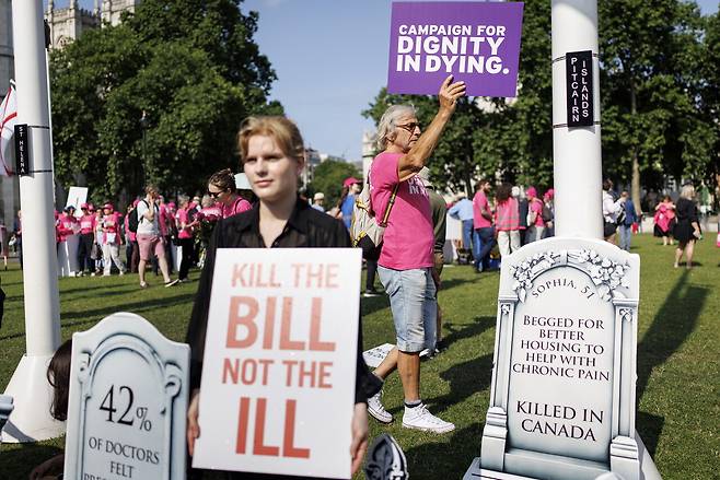 2025년 6월13일 영국 런던에서 안락사 법안을 둘러싸고 찬반 의견이 나뉜 시민들이 팻말을 들고 있다. ⓒEPA