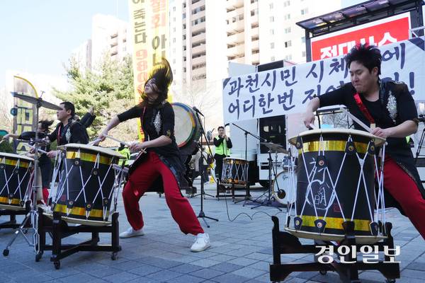 7일 오후 과천 중앙공원에서 진행된  ‘과천 경마공원 이전 반대 2차 시민 총궐기 대회’에서 난타 퍼포먼스가 펼쳐지고 있다. 공연단 뒤에는 ‘과천시민 시체 위에 어디 한 번 지어봐라’라는 현수막이 걸렸다. 2026.3.7  과천/박상일기자 metro@kyeongin.com