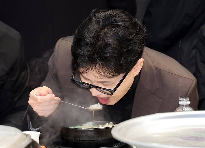 한동훈 전 국민의힘 대표가 7일 부산 북구 구포시장을 방문, 상인 대표 등과 국밥을 먹고 있다./뉴시스
