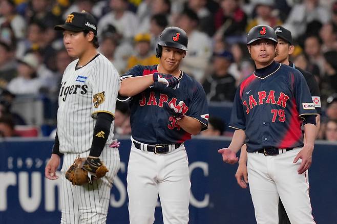 지난 3일 요시다 마사타카(가운데)가 일본 서부 오사카에서 열린 일본 대표팀과 한신 타이거스의 평가전 7회에 안타를 친 뒤 세리머니를 하고 있다. AP연합뉴스