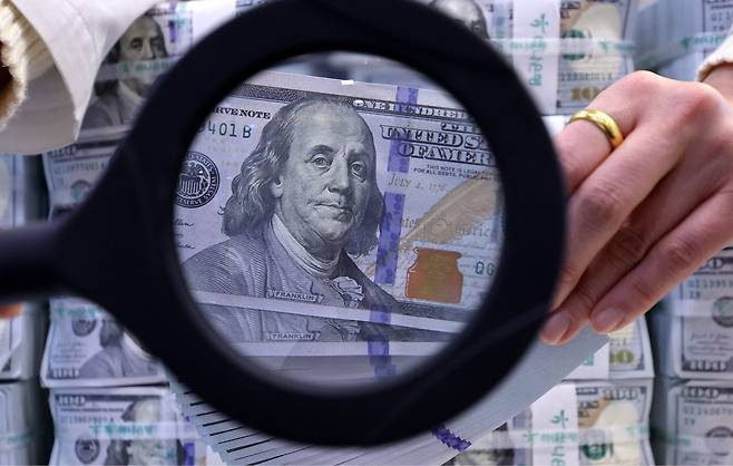 2025년 한미 관세 협상과 국제 정세 악화 등의 영향으로 원달러 환율은 1400원대에서 장기화하고 있다. 사진은 서울 중구 하나은행 위변조대응센터에서 직원이 달러화를 살펴보는 모습. 뉴스1