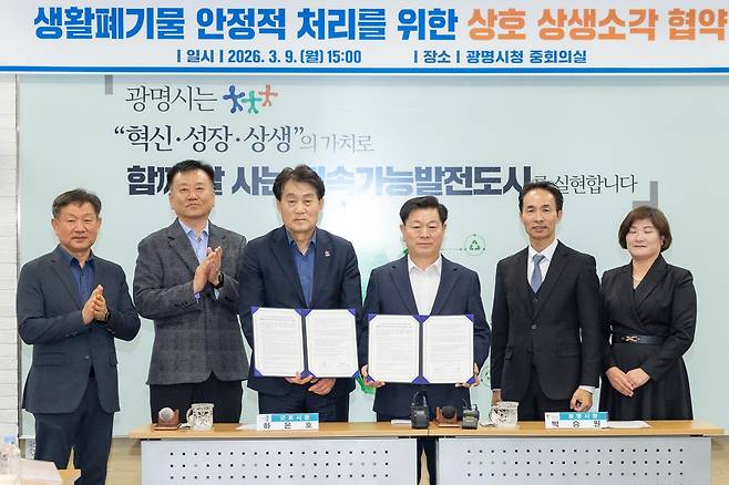 박승원 광명시장(오른쪽에서 세 번 째)이 9일 광명시청 중회의실에서 하은호 군포시장(〃 네 번 째)과 ‘생활폐기물 상생소각 협약’에 서명한 뒤 직원들과 기념사진을 찍고 있다. 광명시 제공