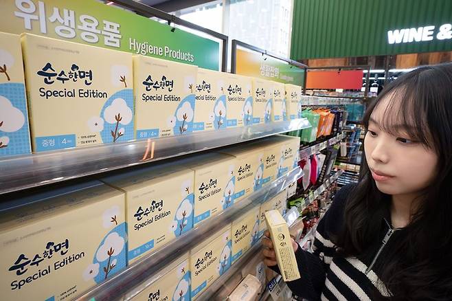 세븐일레븐 모델이 초저가 생리대 상품을 구경하고 있다. 세븐일레븐 제공