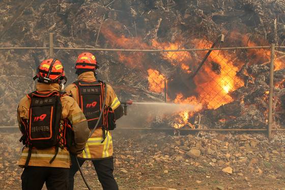 지난해 3월 24일 경북 의성군 점곡면 윤암리 한 야산 아래 민가에서 강풍을 타고 산불이 번지자 현장에 출동한 경상북도 119산불특수대응단이 진화하고 있다. 뉴스1