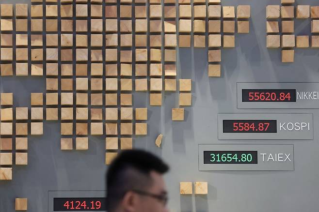 9일 대만 타이베이 대만증권거래소에서 한 남성이 대만 가권지수(TAIEX) 등 시장 지수가 표시된 전광판 앞을 지나가고 있다. 국제유가가 배럴당 100달러를 넘어 급등하면서 아시아 증시가 약세를 보인 가운데 이날 대만 증시는 5% 이상 하락했다. AFP=연합뉴스