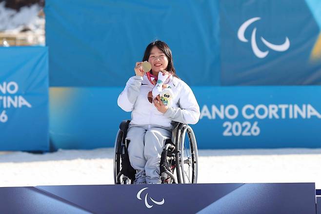 김윤지가 8일(한국시간) 이탈리아 테세로 크로스컨트리스타디움서 열린 2026밀라노·코르티나담페초동계패럴림픽 바이애슬론 여자 개인 좌식 12.5㎞서 우승한 뒤 시상대에 올라 기쁨을 만끽하고 있다. 사진제공｜대한장애인체육회