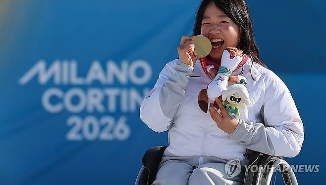 '스마일리' 김윤지, 금맛꿀맛 (테세로=연합뉴스) 한종찬 기자 = 8일(현지시간) 이탈리아 테세로 크로스컨트리 스타디움에서 열린 2026 밀라노·코르티나 동계 패럴림픽 파라 바이애슬론 여자 스프린트 좌식 12.5㎞ 시상식에서 한국 김윤지가 금메달을 목에 걸고 기뻐하고 있다. 2026.3.8 saba@yna.co.kr