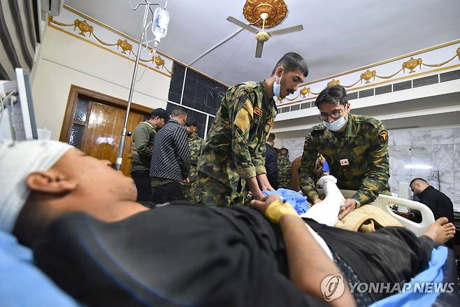 부상당한 인민동원군(PMF) 구성원들 (모술 <이라크> 로이터=연합뉴스) 2026년 3월 7일 이라크 모술에서 부상당한 이라크 인민동원군(PMF) 구성원이 동료들로부터 치료를 받고 있다. 앞서 모술 남쪽에 있는 PMF 본부가 공습을 당했다. (REUTERS/Abdullah Rashid) 2026.3.9.