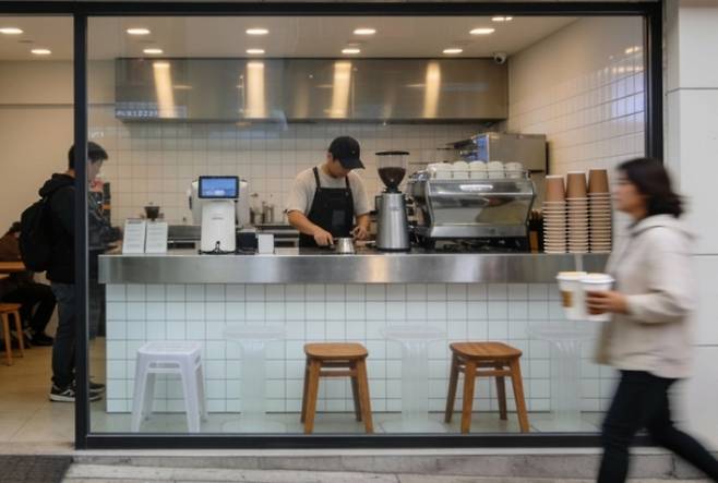 저가 커피의 성공은 초기 '테이크아웃(take-out) 전문 소형 매장'이라는 특성이 팬데믹 시기와 맞물려 가능했다. 팬데믹도 사라진 지금, 매장 면적까지 넓혀가고 있는 저가커피는 언제까지 성장할 수 있을까. / 생성형 AI로 제작한 이미지