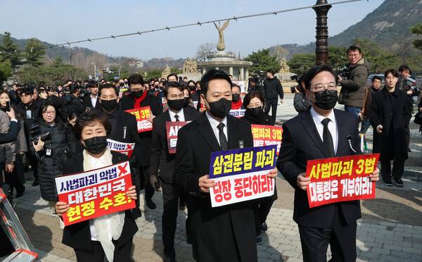 장동혁 대표와 송언석 원내대표를 비롯한 국민의힘 의원들이 5일 청와대 사랑채 앞에서 의원총회를 마친 뒤 손팻말을 들고 청와대 방향으로 이동하고 있다. 2026.3.5. 연합뉴스