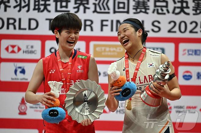 금메달을 딴 안세영(오른쪽)이 2025년 12월21일 중국 항저우 올림픽스포츠센터 체육관에서 열린 세계배드민턴연맹(BWF) 월드 투어 파이널 여자단식 시상식에서 은메달을 딴 중국의 왕즈이와 포즈를 취하고 있다. 안세영이 여자단식 세계랭킹 1위, 왕즈이는 2위다. ⓒ AFP=뉴스1