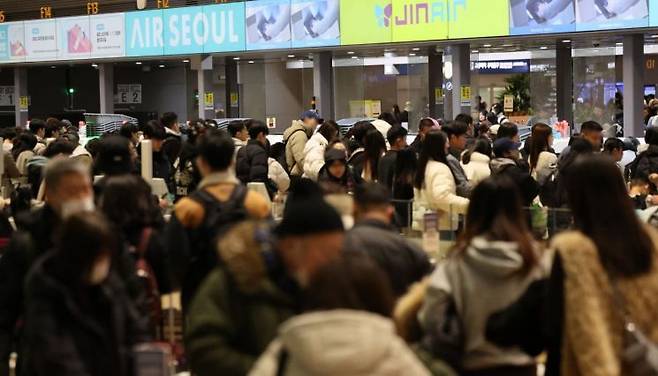 설 명절 연휴를 앞둔 11일 인천국제공항 제2여객터미널 출국장에서 승객들이 탑승 수속을 위해 줄을 서고 있다. 연합뉴스