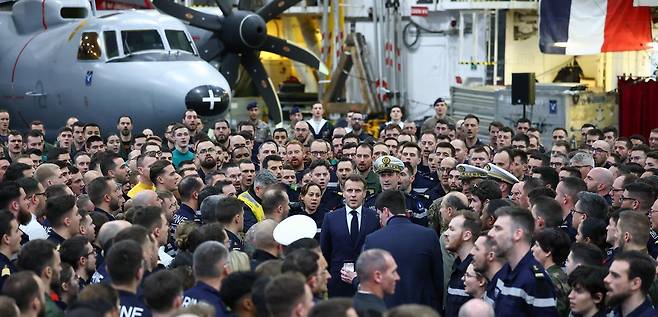 키프로스를 방문한 에마뉘엘 마크롱 프랑스 대통령(가운데)이 9일 파포스 공군기지 인근 해역에 배치된 자국의 샤를 드골 핵추진 항공모함에서 병사들과 만나 국가를 부르고 있다. 그는 이날 “(이란의) 키프로스 공격은 유럽에 대한 공격이나 마찬가지”라며 지중해, 홍해, 호르무즈 해협 등에 군함 10척을 추가로 파견할 예정이라고 밝혔다. 파포스=AP 뉴시스