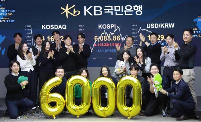 코스피가 종가 기준 사상 처음 6,000선을 돌파한 지난달 25일 서울 영등포구 KB국민은행 딜링룸에서 직원들이 축하 세리머니를 하고 있다. 뉴스1
