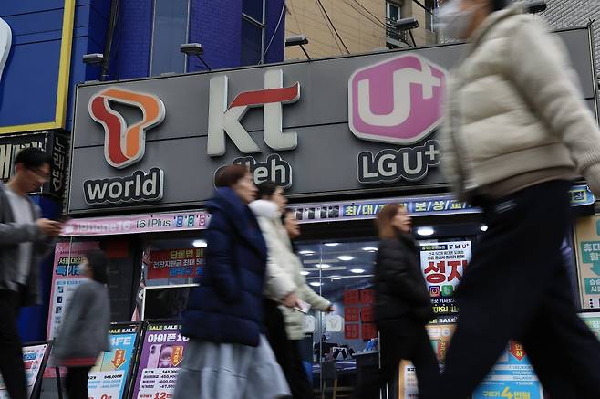 시민들이 서울의 한 휴대폰 매장 앞을 지나가고 있다. 사진=뉴스1