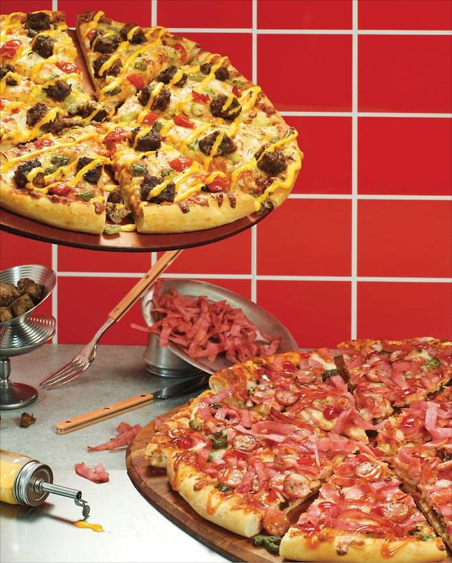 도미노피자의 올해 첫 신제품 ‘아메리칸 클래식 2종’. 그릴드 패티 치즈 버거 피자, 더블 미트 할라피뇨 피자 등 2종으로 이뤄져 있다. /도미노피자 제공