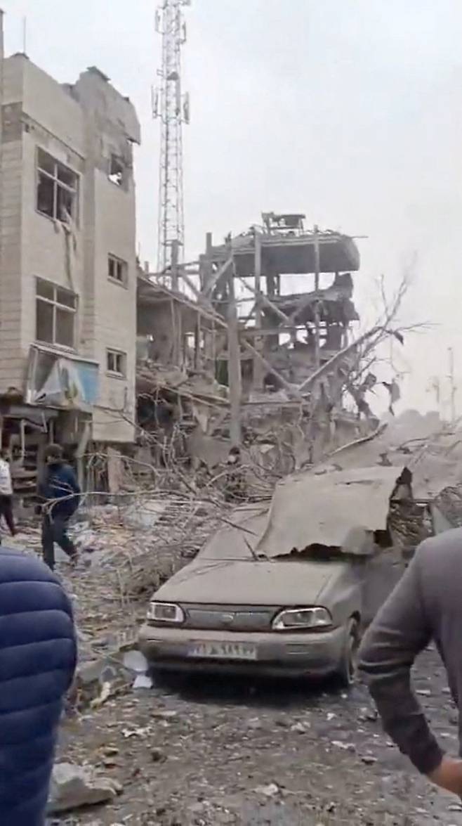 폐허가 된 거리 미국과 이스라엘의 이란 수도 테헤란에 대한 공습으로 파괴된 건물과 차량 주변으로 사람들이 모여 있다. 11일(현지시간) SNS에 공개된 영상을 캡처한 화면이다. 로이터연합뉴스