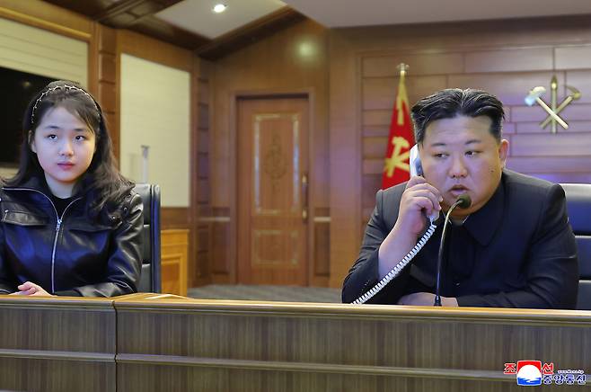 This photo, carried by the North's Korean Central News Agency on Wednesday, shows the North Korean leader Kim Jong-un, right, and his daughter Ju-ae overseeing a test-firing of strategic cruise missiles from the destroyer Choe Hyon via video the previous day. (KCNA-Yonhap)