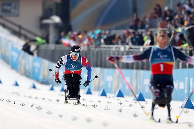 Kim Yun-ji, left, competes in the para cross-country skiing women's sprint sitting final at the 2026 Milan-Cortina Winter Paralympics at the Tesero Cross-Country Skiing Stadium in Italy on March 10. [KOREA PARALYMPIC COMMITTEE]