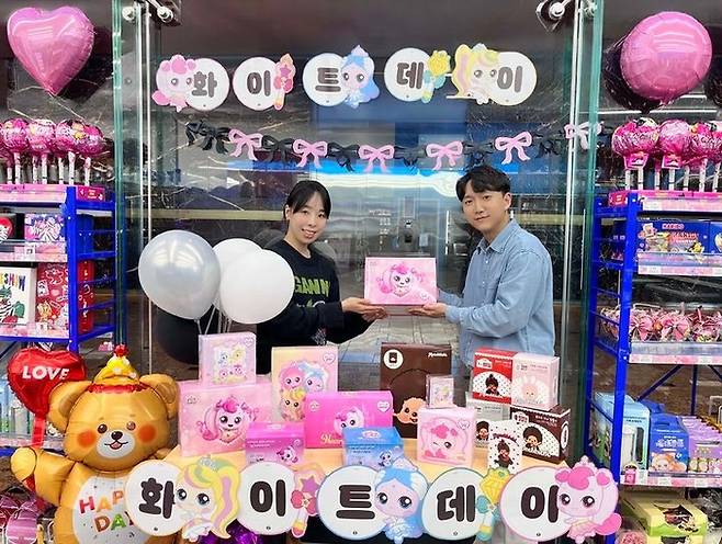 GS25에서 모델이 화이트데이 행사 상품 앞에서 포즈를 취하고 있다. [GS리테일 제공]