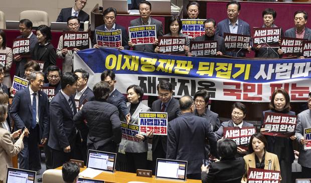 27일 국회에서 열린 2월 임시국회 8차 본회의에서 전날 상정된 헌법재판소법 일부개정법률안(재판소원제)에 대한 무제한 토론(필리버스터) 종결을 위한 투표가 시작되자 국민의힘 의원들이 손팻말과 피켓을 들고 시위를 펼치는 동안 민주당 양문석 의원과 국민의힘 서명옥 의원이 설전을 벌이고 있다. 연합뉴스