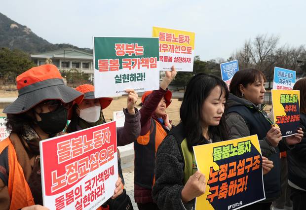 11일 서울 청와대 앞에서 민주노총 주최로 열린 돌봄노동자 처우개선 및 범정부 공동교섭 촉구 기자회견에서 참가자들이 손팻말을 들고 있다. 연합뉴스