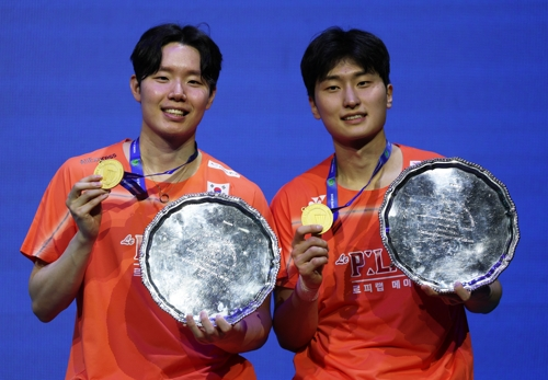 서승재-김원호가 9일 전영오픈 우승 뒤 트로피와 금메달을 들어보이고 있다.  로이터연합뉴스