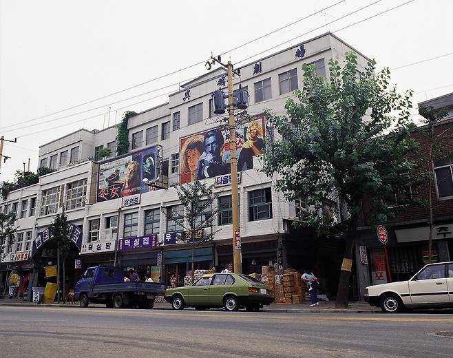 한국전쟁 이후 인천 동구 송현동 일대에 형성돼 최근까지 자리를 지켰던 양키시장(송현자유시장)이 지난 6월 보상절차를 끝으로 문을 닫았다. 양키시장이 철거된 후 경인전철 동인천역 일대에서는 개발사업이 진행된다. 1980년대 영화 포스터가 걸린 오성극장 전경. /유동현 전 인천시립박물관장 제공