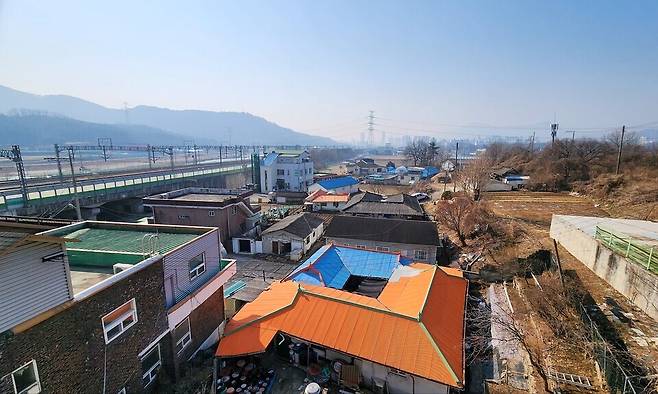 ▲ 양주의 관문인 양주1동 위로 수도권 전철이 쉴 새 없이 지나가고 있지만, 선로 옆 주택가는 수십 년째 개발제한구역(그린벨트)에 묶여 있다. 낡은 지붕과 대조되는 전철의 모습이 양주 1동 주민들이 처한 '개발 소외'의 현실을 극명하게 보여주고 있다.