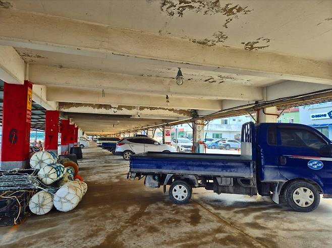 오징어로 가득차야할 울릉도 저동항 위판장에 차량들만 가득차 있다. 홍준기 기자