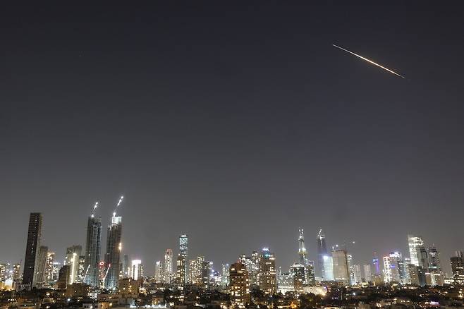이스라엘 텔아비브에서 11일 미사일로 추정되는 발사체가 상공을 가로 지르고 있다. 이스라엘에서는 이란 전쟁 이후 자국으로 날아드는 이란 미사일 및 드론, 그 피해에 대한 보도를 금지하는 언론 검열을 엄격히 시행하고 있다. EPA 연합뉴스
