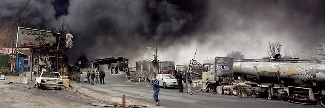 < ‘검은 비’ 내리는 테헤란 > 8일(현지시간) 이스라엘의 공습으로 이란 테헤란 인근 샤흐란 정유시설에서 대규모 화재가 발생해 검은 연기가 하늘을 뒤덮었다. 이스라엘은 이날 테헤란 일대 석유 저장시설 네 곳을 집중 공격했다. 지난달 28일 전쟁이 시작된 이후 이란 석유 시설이 공격받은 것은 이번이 처음이다. 테헤란 일대에 기름이 섞인 ‘검은 비’가 내리기도 했다. ﻿  EPA연합뉴스