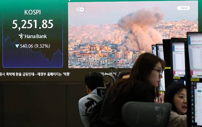 이란전쟁 여파로 코스피·코스닥에 서킷브레이커가 발동하는 등 증시가 급락한 지난 4일 서울 중구 하나은행 본점 딜링룸 전광판에 중동분쟁 관련 뉴스가 나오고 있다./사진=뉴스1