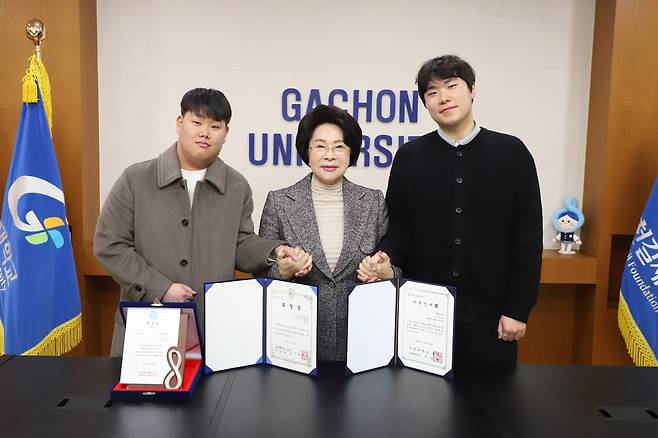 가천대 이길여 총장이 12일 가천관에서 행정학과 김성규 학생(사진 오른쪽)과 한국어문학과 김동규 졸업생(사진 왼쪽)을 총장실로 직접 초청, 가천인재상을 수여한 뒤 기념촬영을 하고 있다.[가천대 제공]