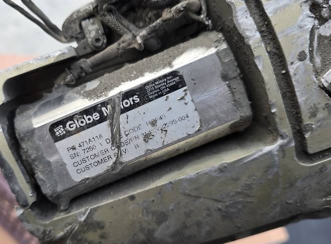 최소 175명의 어린이와 교사가 숨진 지난달 28일 이란 여자초등학교 폭격이 미군의 표적 설정 오류에서 비롯됐을 가능성이 크다는 예비 조사 결과가 나왔다. 이란 측은 현장에서 수거한 미사일 파편에서 미군 토마호크 미사일 부품이 확인됐다고 주장했다. 사진은 폭격 현장에서 수거된 미사일 파편. ‘메이드 인 USA’ 문구와 함께 글로브 모터스라는 제조사명이 표기돼 있었는데, 이 부품은 토마호크 의 후미 조종면 제어계통에 들어가는 전동식 구동기(액추에이터)일 가능성이 크다. 유도·비행제어장치의 조향 명령에 따라 꼬리날개 등 조종면을 미세하게 움직여 비행 방향 수정과 자세 제어, 경로 유지를 수행하는 핵심 구동부로 추정된다. 2026.3.11 이란 외무부 대변인