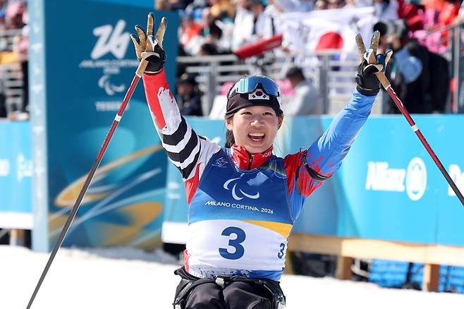 김윤지가 13일(현지시간) 이탈리아 테세로 크로스컨트리 스타디움에서 열린 2026 밀라노·코르티나 동계패럴림픽 여자 바이애슬론 스프린트 추적 좌식에서 은메달을 따낸 후 환호하고 있다. 이번 대회에서 메달 4개를 땄고, 손가락 4개 펼쳤다. 사진 | 대한장애인체육회