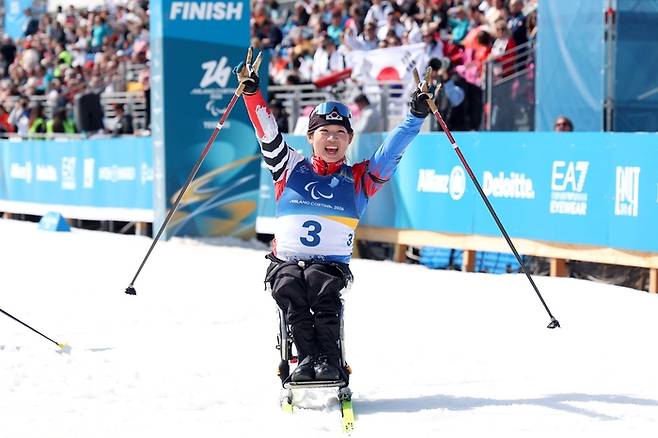 김윤지가 13일(현지시간) 이탈리아 테세로 크로스컨트리 스타디움에서 열린 2026 밀라노·코르티나 동계패럴림픽 여자 바이애슬론 스프린트 추적 좌식에서 은메달을 따낸 후 환호하고 있다. 이번 대회에서 메달 4개를 땄고, 손가락 4개 펼쳤다. 사진 | 대한장애인체육회