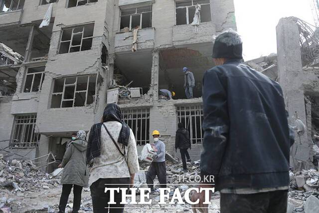 이란 시민들이 12일(현지시간) 테헤란의 손상된 건물에서 생필품을 찾고 있다. /테헤란=신화.뉴시스