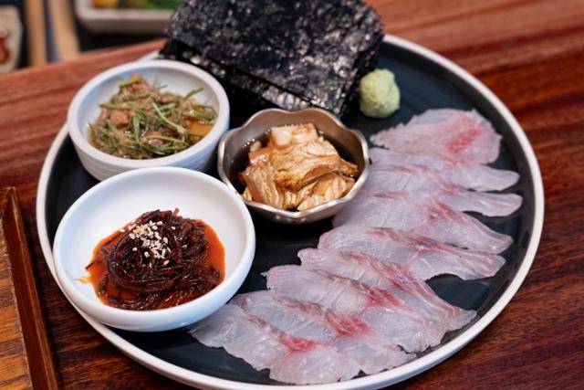 서울 영등포 얼쑤 비스트로에서 판매하는 숙성회 쌈. 벵에돔, 고춧가루 이전의 장김치를 응용한 배추간장 절임, 김칫국물로 만든 묵덕장으로 무쳐낸 세발나물, 초장 대신 장아찌 장물을 활용한 꼬시래기와 다시마 무침을 담아냈다. 장준우 제공