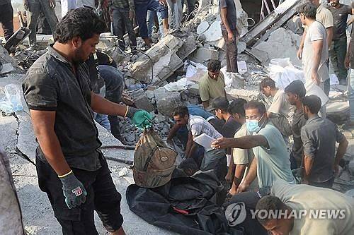 공습으로 파괴된 이란 초등학교 잔해와 구조대원들. 로이터=연합뉴스