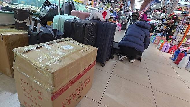 12일 오전 중국 랴오닝성 단둥시 대형 쇼핑몰 신류시장에서 한 북한인 남성이 구매한 물건을 여행용 가방에 담고 있다. 사진 이도성 특파원