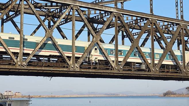 12일 오후 6년 만에 복원된 평양발 베이징행 여객열차가 중국 랴오닝성 단둥시 중조우의교를 건너고 있다. 사진 이도성 특파원