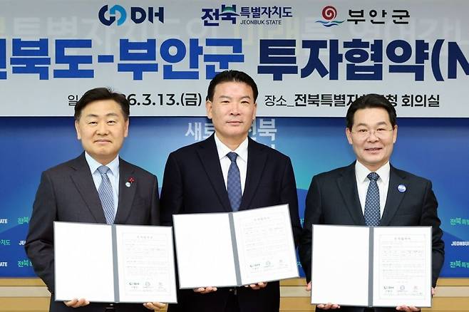 이정권 DH그룹 회장(가운데)이 13일 전북도청에서 김관영 전북도지사(왼쪽), 권익현 부안군수와 부안 제3농공단지 일원에 첨단 제조·연구 거점을 조성하기 위한 투자 협약(MOU)을 체결한 뒤 협약서를 들어 보이고 있다. 전북도 제공