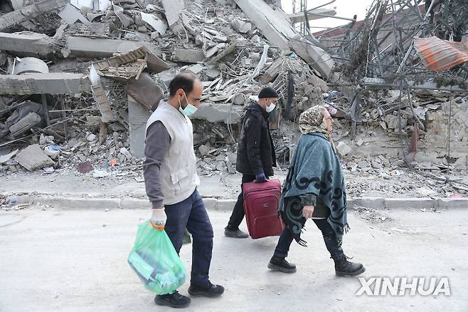 폐허가 된 테헤란 시내  (신화=연합뉴스) 이란 테헤란 시민들이 12일(현지시간) 무너진 건물 옆을 걸어가고 있다. 2026.3.12 [재판매 및 DB 금지]