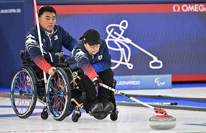 휠체어컬링 방민자가 13일(현지시간) 이탈리아 코르티나담페초 컬링 올림픽 스타디움에서 열린  2026 밀라노 코르티나 패럴림픽 휠체어컬링 혼성 4인조 캐나다와의 준결승전에서 스톤을 힘차게 밀고 있다. 사진 | 코르티나=사진공동취재단
