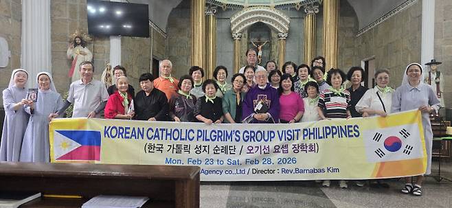 롤롬보이 본당에서 미사를 마친 후 김정수 신부와 롤롬보이 본당을 지키는 수녀들과 순례자들이 함께 하고 있다.