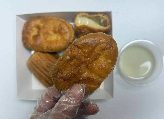 버터떡을 집어 든 모습. 연유 소스를 함께 제공한다. 9500원이다. (사진=한전진 기자)