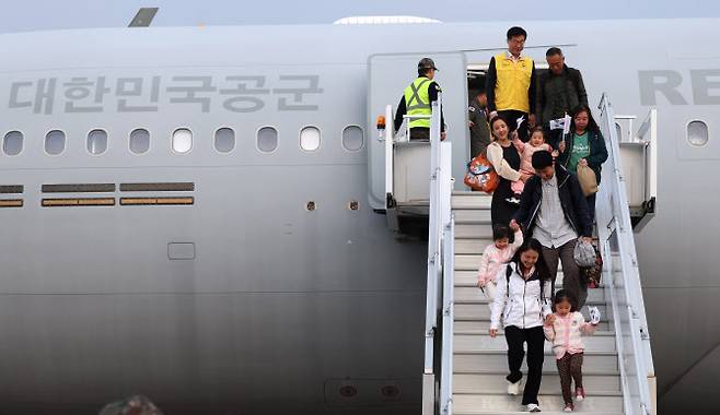 15일 오후 경기도 성남시 서울공항에서 중동 상황 악화로 공군 다목적 수송기 KC-330 ‘시그너스’를 타고 귀국한 현지 체류 교민들이 밝은 표정으로 발걸음을 옮기고 있다. [공동취재단]