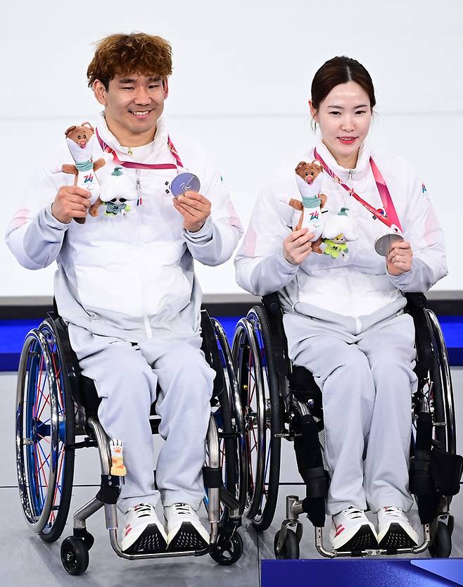 휠체어컬링 믹스더블 백혜전-이용석 조가 11일(현지시간) 이탈리아 코르티나 컬링 올림픽 스타디움에서 열린 2026 밀라노·코르티나 동계패럴림픽 휠체어컬링 믹스더블 결승에서 중국을 만나 연장 접전 끝에 아쉽게 패하며 은메달을 목에 걸었다. 시상식 후 백혜진(오른쪽)과 이용석이 메달을 들고 포즈를 취했다. 한국 휠체어컬링은 2010 밴쿠버 대회 이후 16년 만에 메달을 따냈다. 사진 | 대한장애인체육회