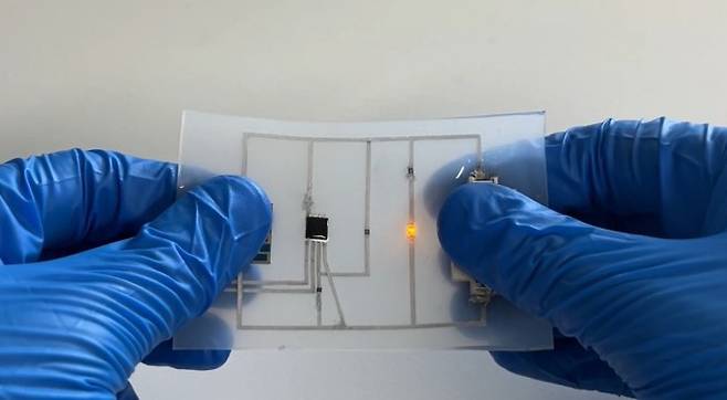 액체금속 파우더로 유연한 필름 위에 그린 전자회로. 구부려도 회로가 끊어지지 않고 LED가 정상 작동한다. KAIST 제공